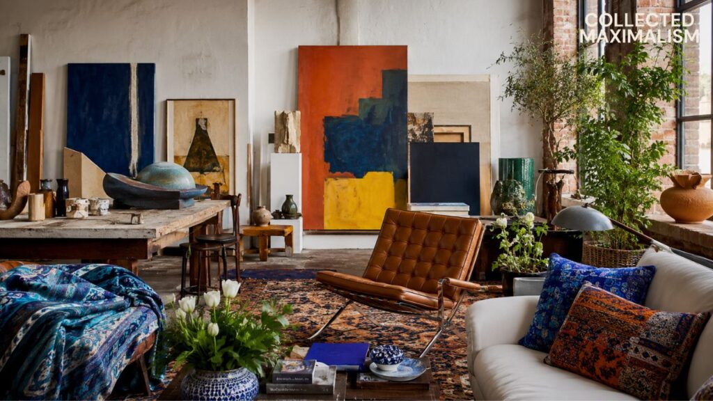 New York Soho loft aesthetic featuring exposed brick walls, oversized abstract art, vintage furniture, Persian rugs, layered textiles, and collected maximalist decor.