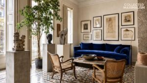 Mediterranean interior design with terracotta plaster walls, oversized artwork, antique mirror, rustic wood coffee table, and collected maximalist styling.